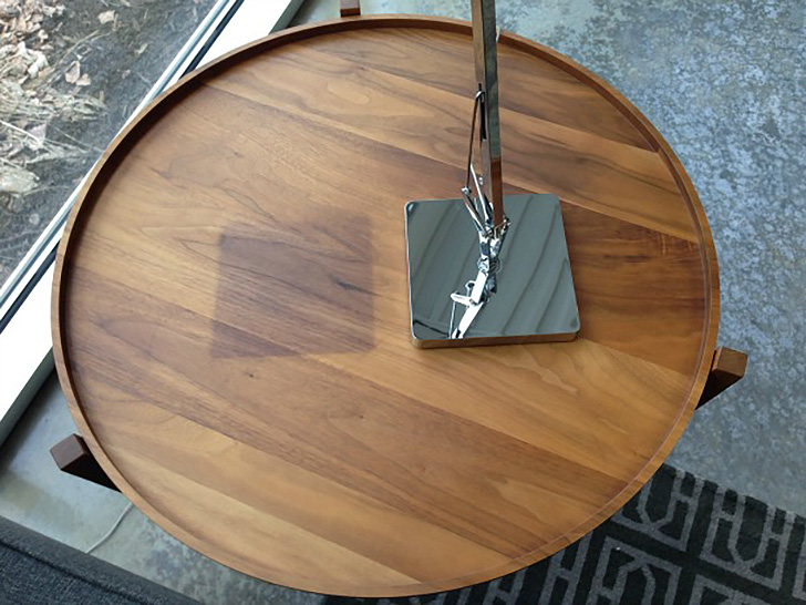Walnut coffee table with dark spot from lamp base protecting against sunlight