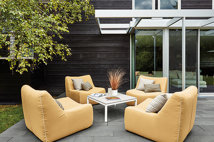big yellow upholstered outdoor lounge chairs surrounding small coffee table