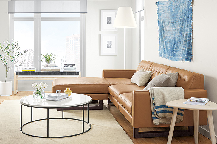 Wells leather sofa with round Tyne coffee table and indigo wall tapestry
