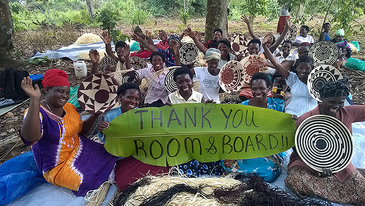 Ugandans holding hand-woven basekts made for Room & Board