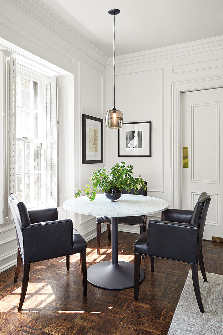 Round Aria table with white quartz top and three Marie leather arm chairs