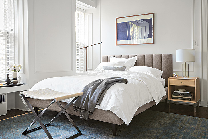 Hartley upholstered bed with all white bedding, Brazo floor lamp and Karr leather stool