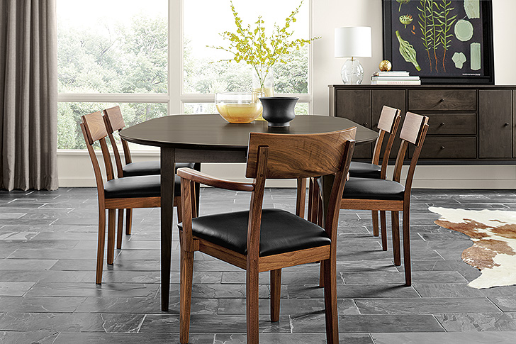 Danish-inspired Doyle dining chairs in walnut with leather seats around round extension table