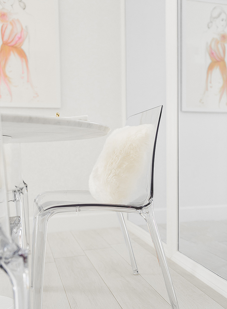 Clear plastic dining chair with sheepskin pillow