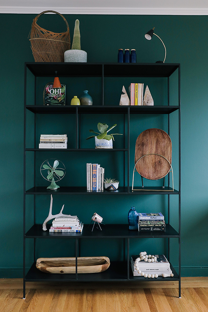 Natural steel bookcase against green wall