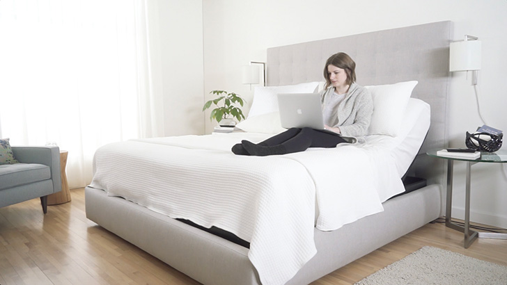 adjustable bed in use with woman working on laptop