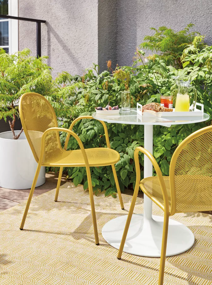 Aria round table and 2 Rio yellow outdoor chairs.