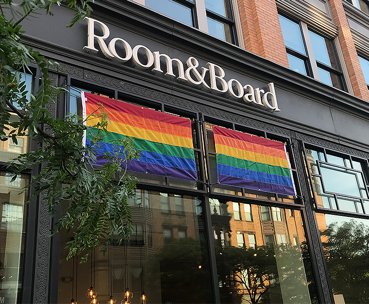 Two rainbow flags hang in the windows for pride in Boston
