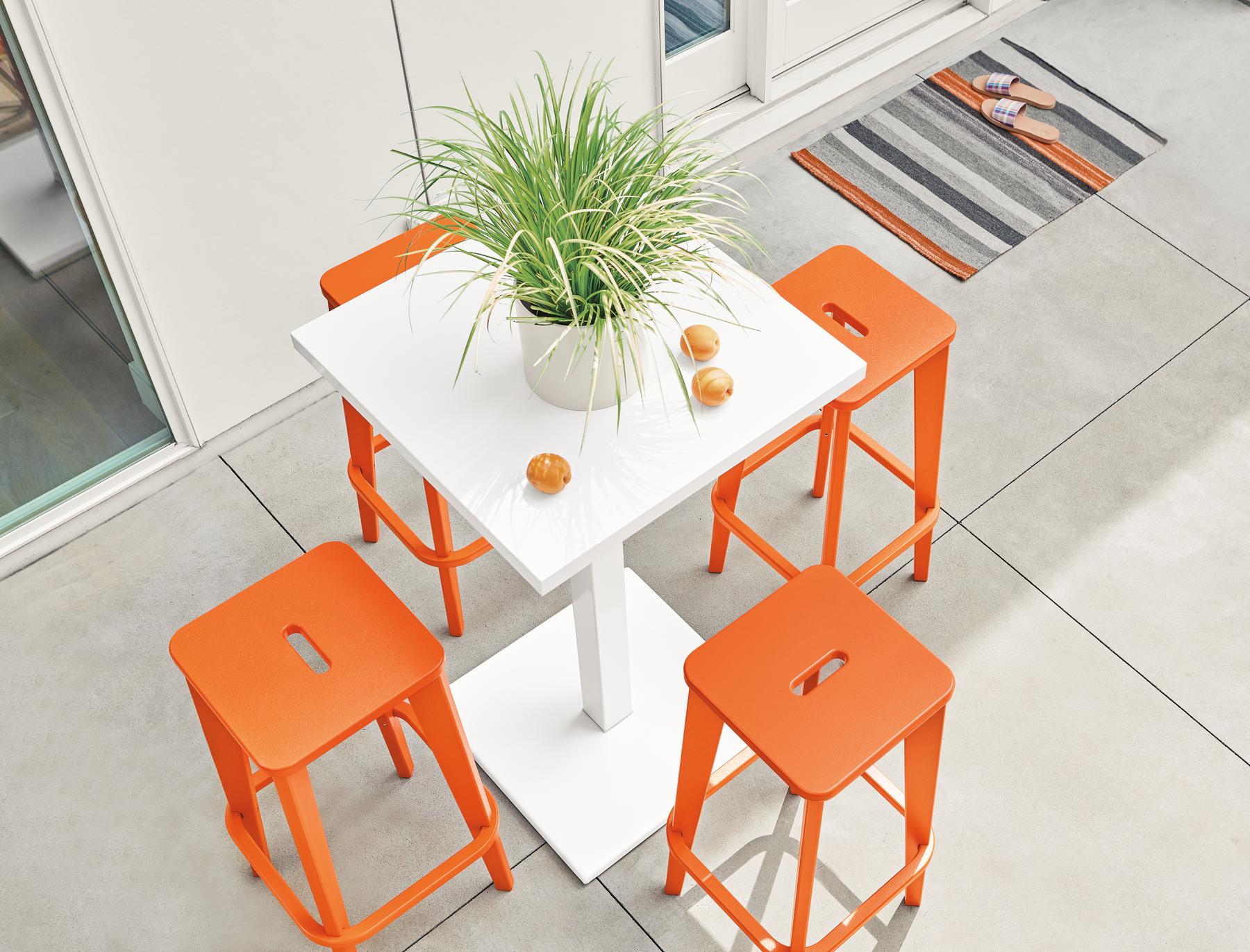 Detail of four Brook bar stools in orange on patio.