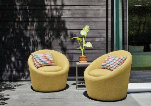 Outdoor space with two Crest swivel chairs in Pelham Citron fabric.