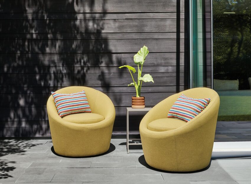 Outdoor space with two Crest swivel chairs in Pelham Citron fabric.