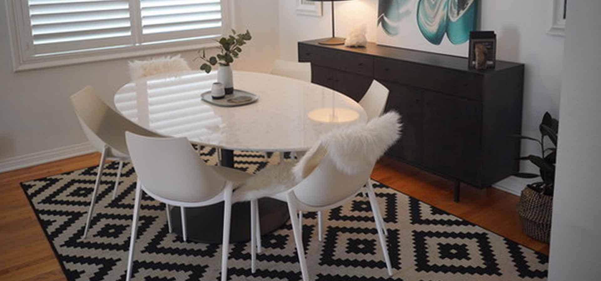 Dining room with white table and chairs and patterned rug