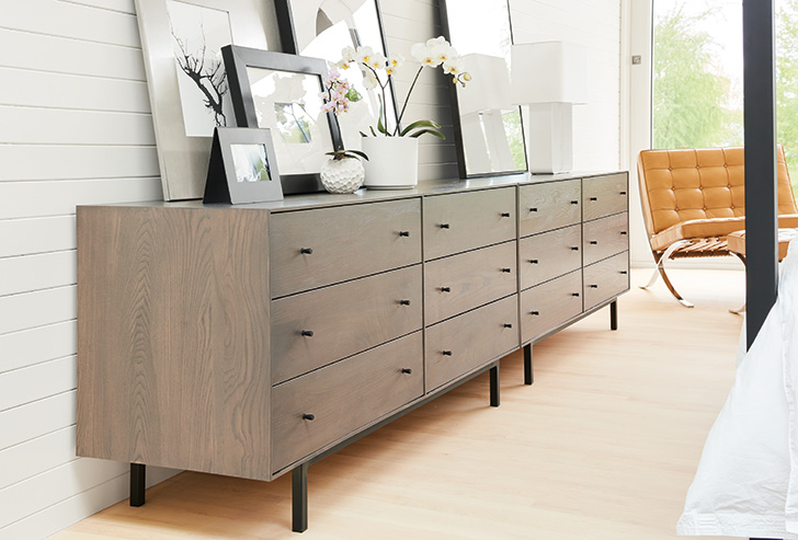Two modern Hudson wood and steel dressers with assorted picture frames on top
