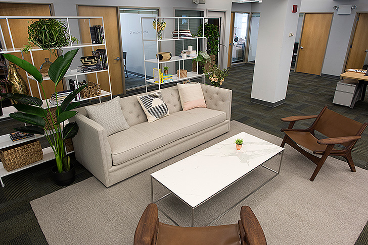 Well+Good office space with sofa, coffee table and leather lounge chairs