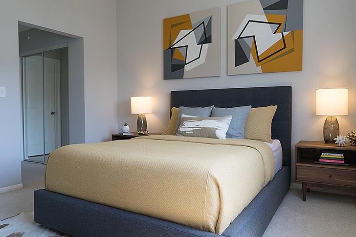 Upholstered blue bed with yellow bedding