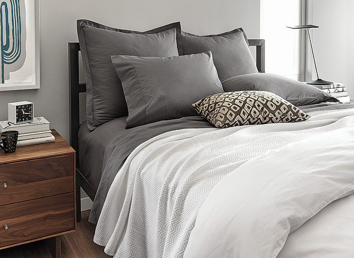 modern gray and white bedding with steel bed frame