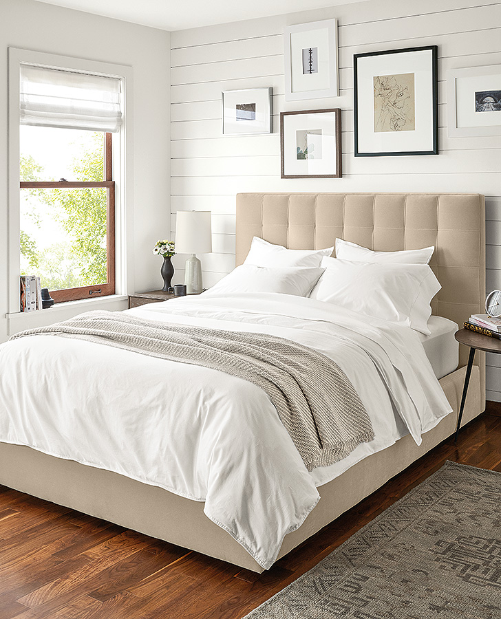 modern all white bedding with tan upholstered bed