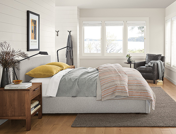 grey upholstered bed with modern colorful bedding