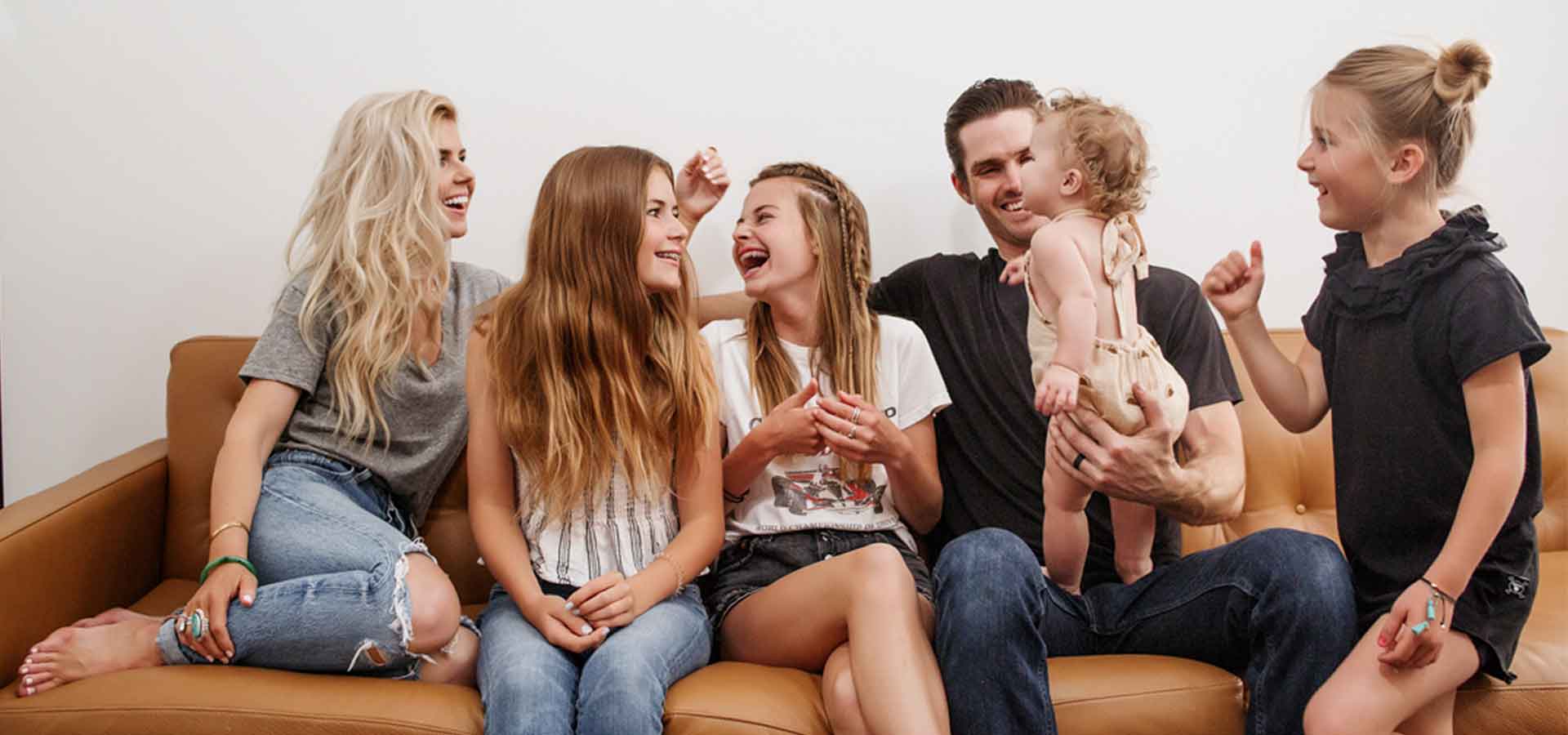 Lisa Allen and her family sitting on leather sofa