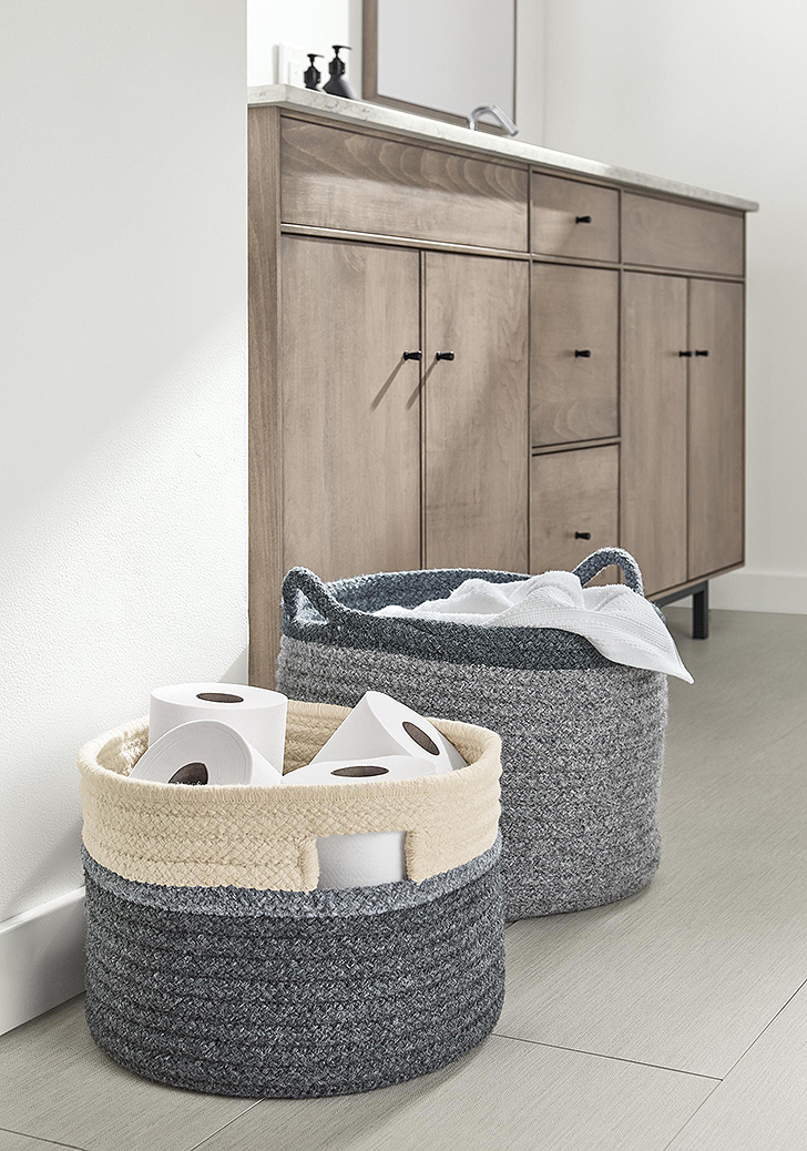 Two baskets in bathroom filled with toilet paper and towels
