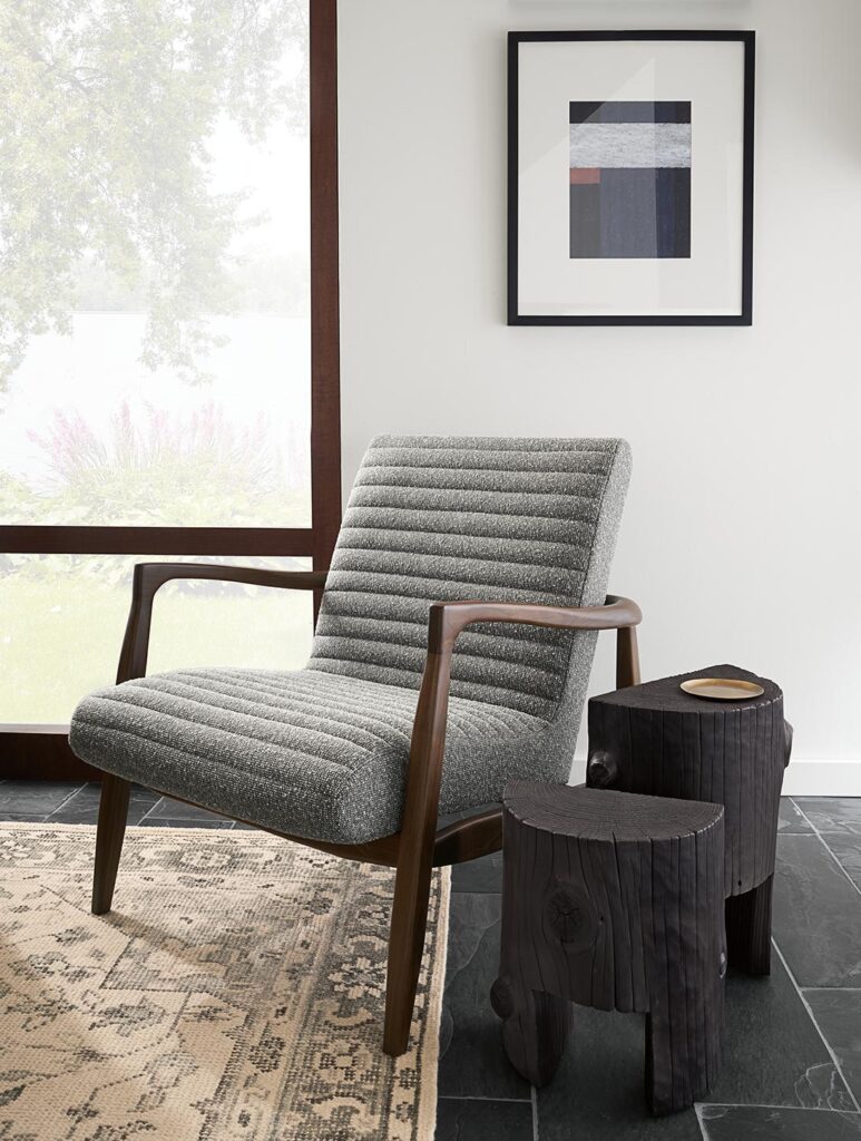 Callan chair in walnut and gray fabric beside two Casetta end tables. 