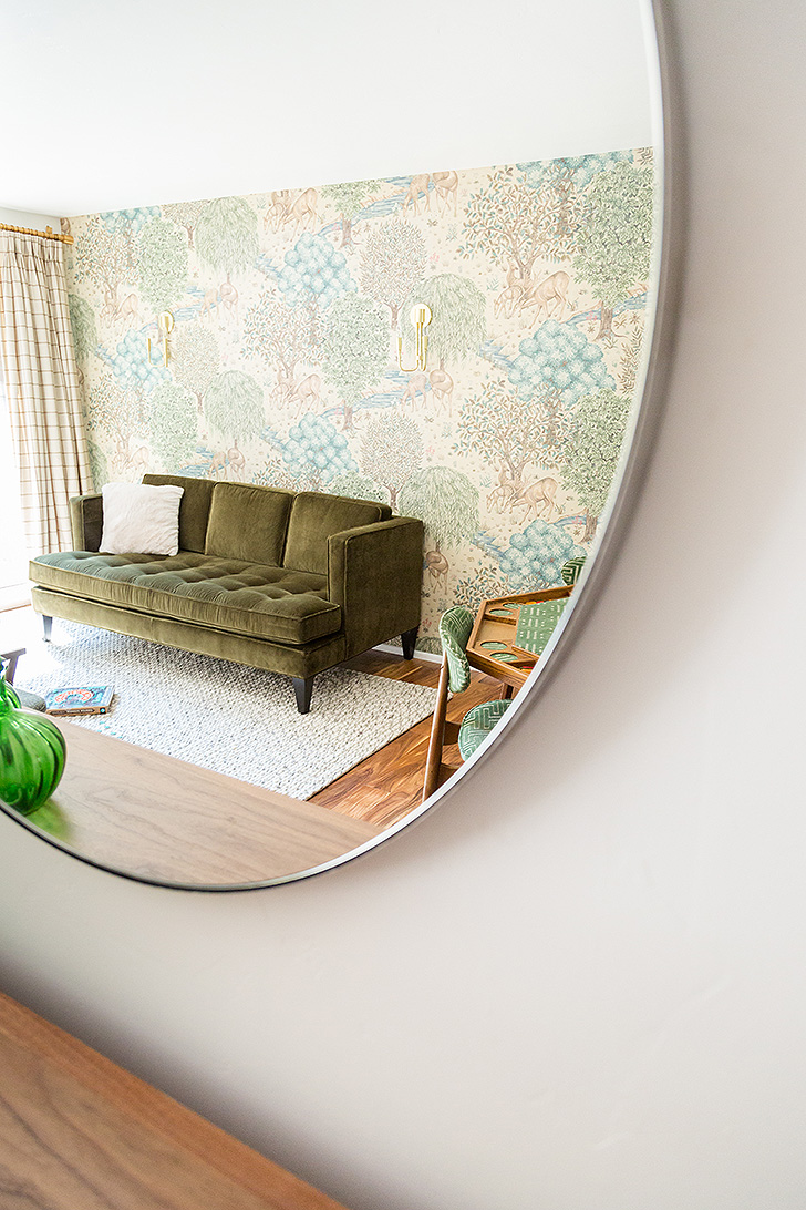 Reflection of green velvet sofa in mirror
