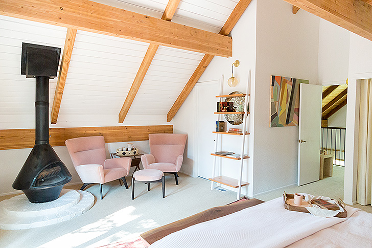 Master bedroom in A-frame cabin with pink velvet lounge chairs