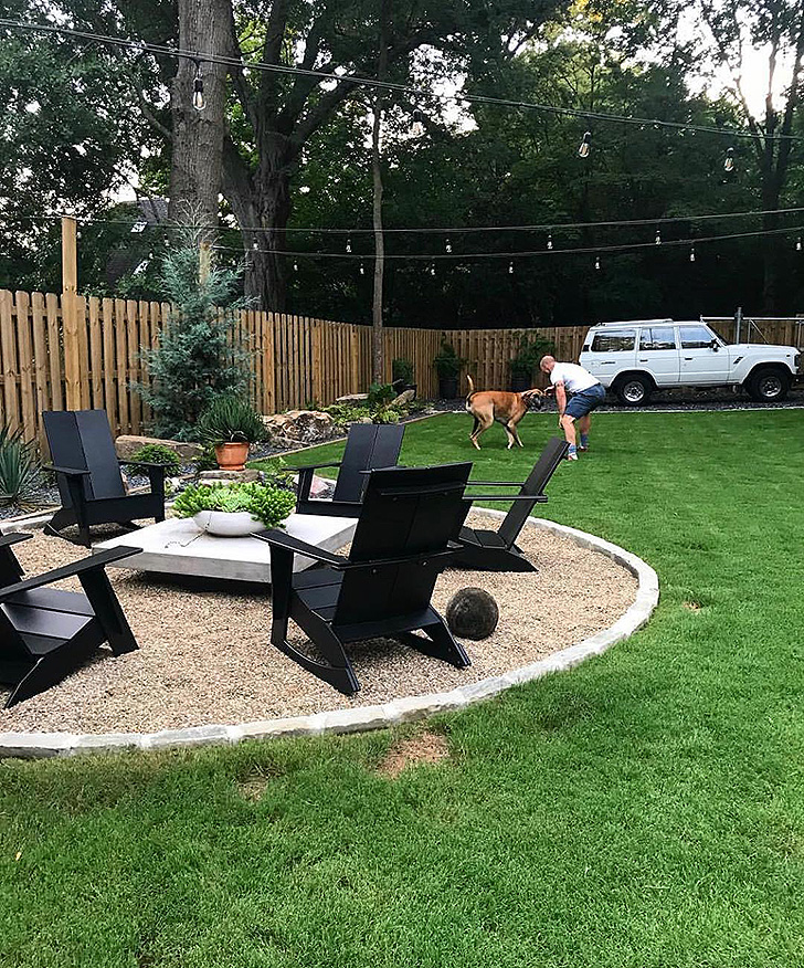 Four black outdoor chairs around a firepit