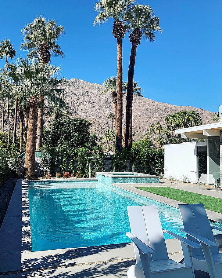 Two white outdoor chairs by the pool