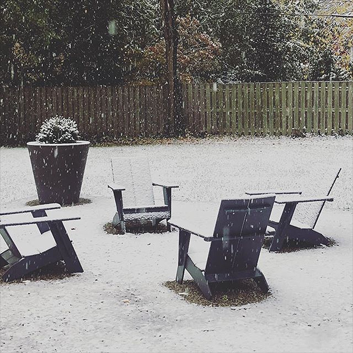 Four outdoor chairs covered in snow