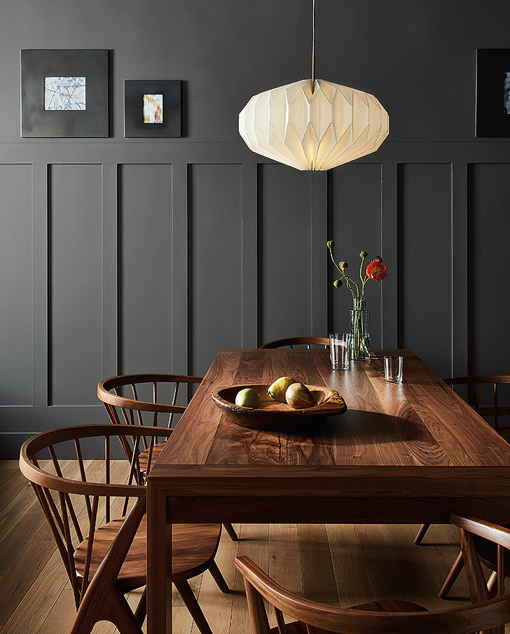Black painted dining room wall with wood dining set