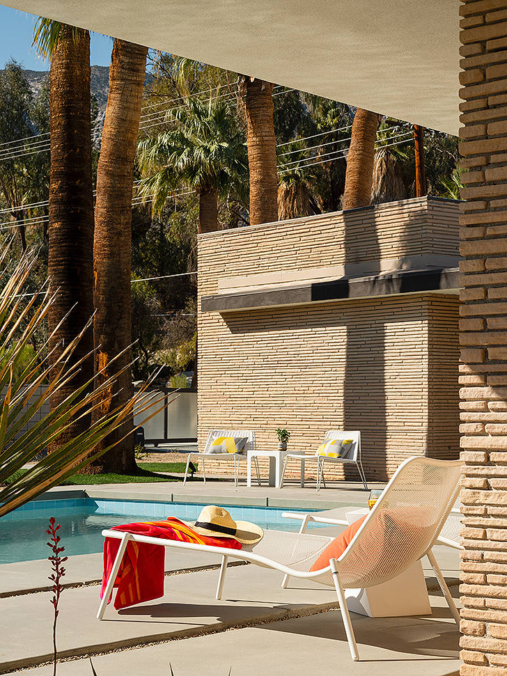 Outdoor lounge chair overlooking view of palm trees