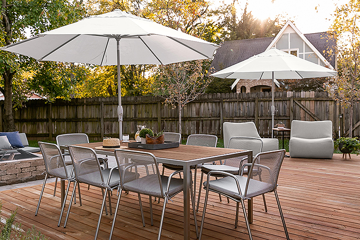 Dining chairs around an outdoor dining table with an umbrella