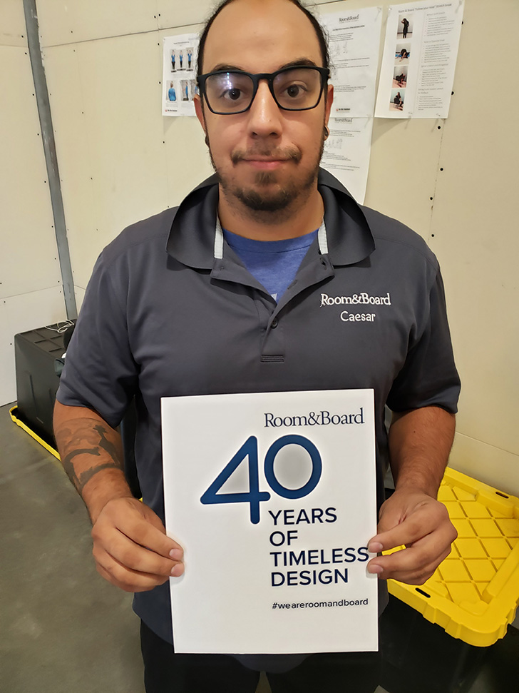 Dallas Delivery Center staff member with 40th anniversary sign.