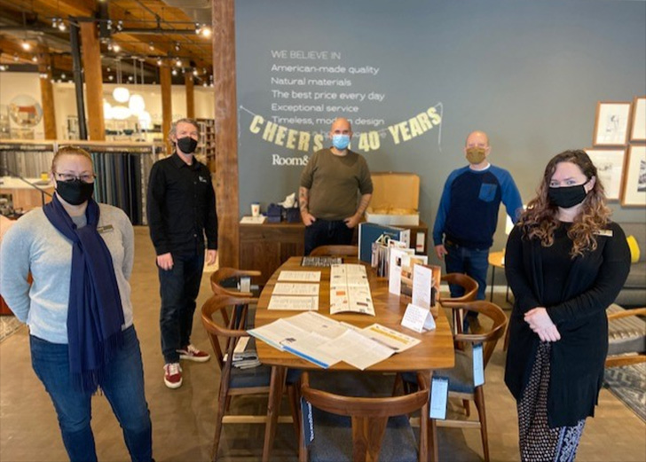 Staff members stand around a table in Portland showroom.