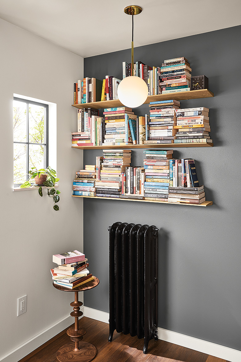 Detail of bookshelves in corner with charcoal paint on wall