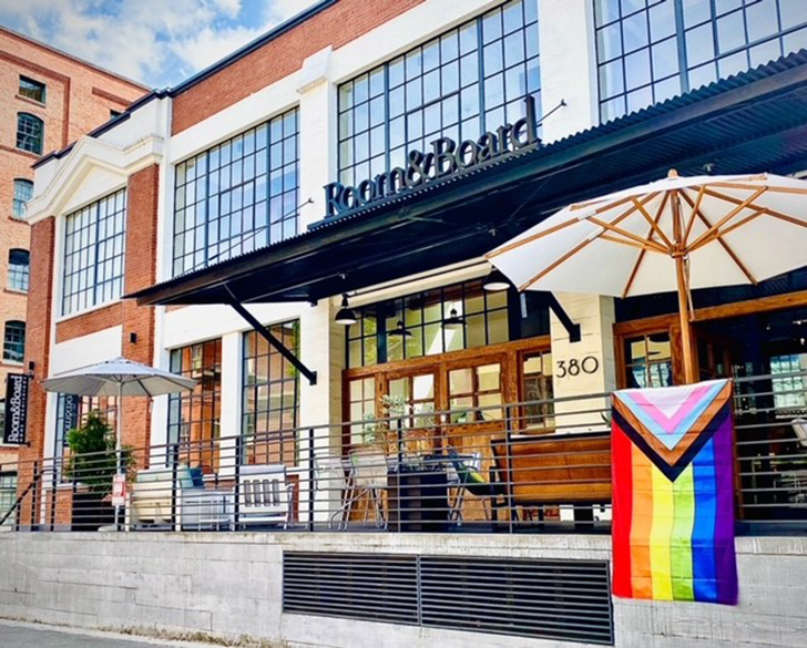 Exterior photo of our Portland store showing the outdoor furniture and a Pride flag hanging from a railing.
