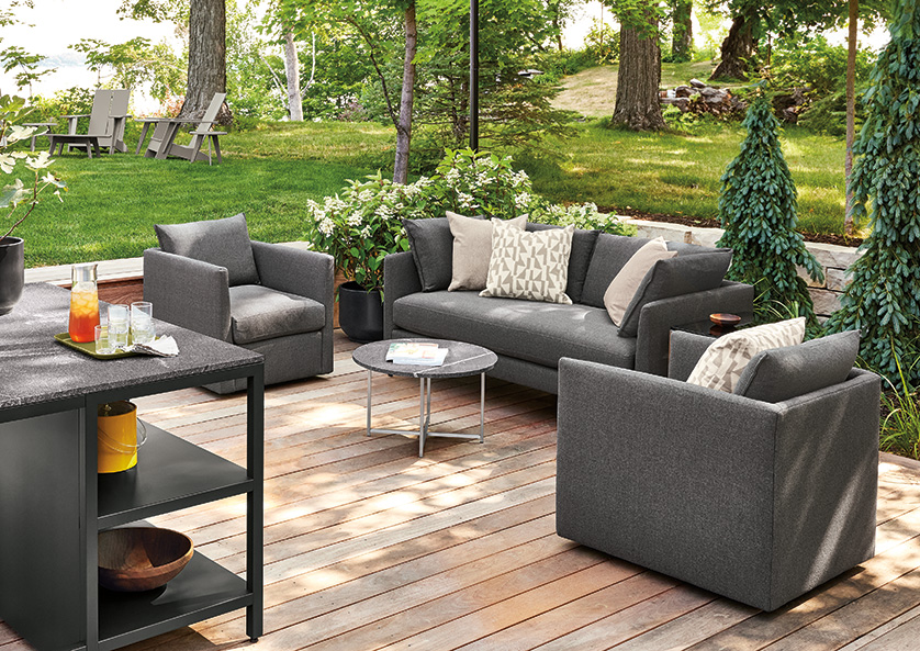 Outdoor space on a lake in summer with with Parsons outdoor counter table, Montego stools, Palm lounge furniture and Emmet Adirondack chair.