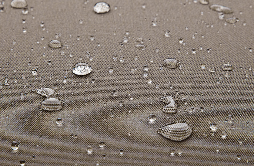 Closeup image that shows water beading up on a taupe-colored outdoor fabric.