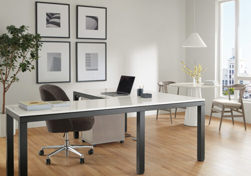 Office area with Parsons Adjustable height standing desk in graphite and light grey quartz top in seated position with Cora office chair.