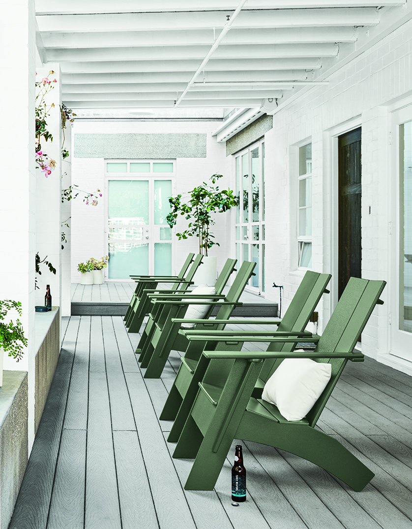 Six green Emmet Adirondack chairs on a covered porch.