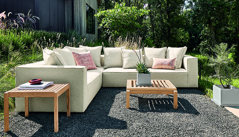 Sectional with loose-back cushions and two wood accent tables.