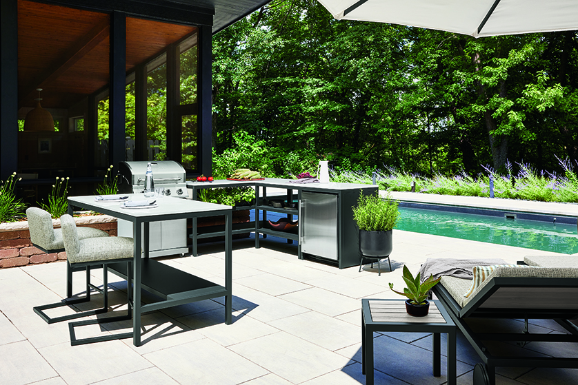 Outdoor kitchen with console table, grill, counter space and built-in refrigeration.