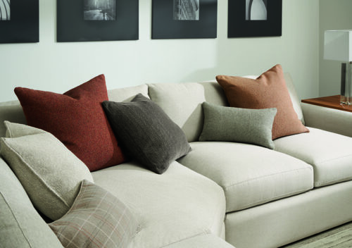 detail of custom throw pillows on white sofa.