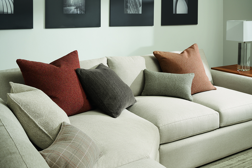 detail of custom throw pillows on white sofa.